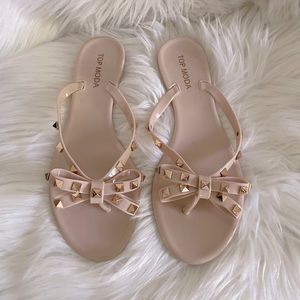 Light pink/nude Top Moda flip flops with gold studding and bow.